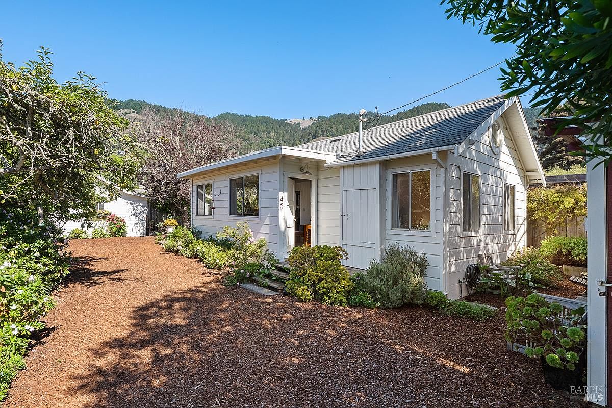Cottage 40 from the front, white siding, mountain backdrop
